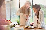 Pregnant mother serving food for daughter at dining table