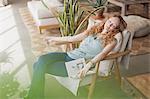 Serene woman with book napping in armchair