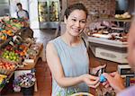 Woman paying with credit card at grocery store checkout