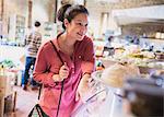 Smiling woman pointing at display case in grocery store