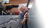 Mechanic examining car panel in auto repair shop