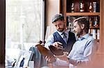 Businessmen examining dress shoes in menswear shop