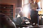 Tailor and businessman browsing fabric in menswear shop