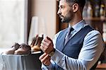 Businessman looking through window in menswear shop