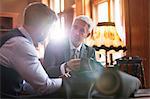 Tailor and businessman discussing suit in menswear shop