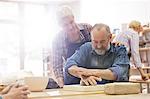 Senior couple molding clay in pottery studio