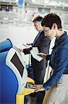 Business people using self service check-in machine at airport