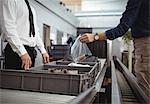 Passenger putting plastic bag into tray for security check at airport