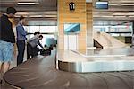 People waiting for luggage in baggage claim area at airport