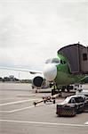 Airplane with loading bridge getting ready for departure at airport terminal