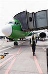 Airport ground crew walking on runway at airport terminal