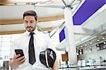 Pilot using mobile phone in airport terminal