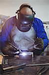 Male welder working on a piece of metal in workshop