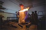 Male welder holding welding torch in workshop