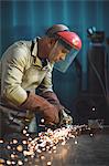 Male welder working on a piece of metal in workshop