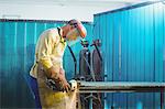 Male welder working on a piece of metal in workshop