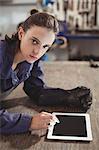 Portrait of female welder using digital tablet in workshop