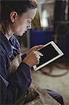 Female welder using digital tablet in workshop