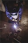 Female welder working on a piece of metal in workshop