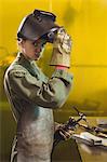 Female welder holding welding torch in workshop