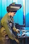 Female welder using clamp tool in workshop