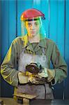 Portrait of female welder holding circular saw in workshop