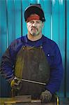 Male welder holding welding arch in workshop