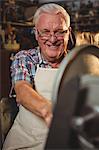 Portrait of smiling shoemaker working in workshop