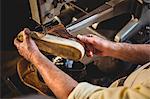 Shoemaker using sewing machine in workshop