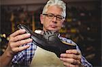 Shoemaker examining a shoe in workshop