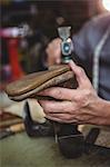 Shoemaker hammering on a shoe in workshop