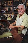 Portrait of shoemaker repairing a shoe in workshop