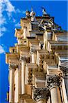 Low angle view of the ornate mouldings and pillars of the Cathedral of Saint George (Duomo di San Giorgio) against a blue sky in Ragusa in Sicily, Italy