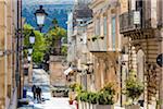 Quiet, picturesque street lined with lanterns and old, stone buildings in Ragusa in Sicily, Italy