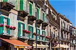 Detail of row of buildings with balconies and shuttered windows in Modica in the Province of Ragusa in Sicily, Italy