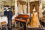 Room interior with piano and mannequins dressed in historical clothing at Donnafugata Castle in Ragusa in the province of Ragusa in Sicily, Italy