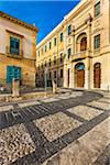 Stone buildings and inlayed designs in the cobblestone streets of Noto in the Province of Syracuse in Sicily, Italy