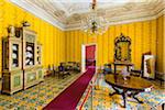 Dining room with yellow walls and mosaic floor inside the Palazzo Nicolaci in Noto in the Province of Syracuse in Sicily, Italy