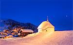 Blue dusk on the alpine village and church covered with snow, Bettmeralp, district of Raron, canton of Valais, Switzerland, Europe