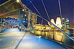 People strolling on the Helix Bridge towards the Marina Bay Sands and ArtScience Museum at night, Marina Bay, Singapore, Southeast Asia, Asia