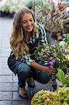 Happy woman looking at flowers at her shop