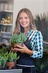 Portrait of a happy woman holding a potted plant