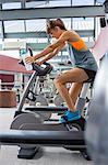 Young woman exercising on a machine in a fitness club