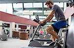 Man exercising on a spin machine in gym