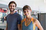 Happy young couple standing in a gym