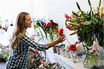 Side profile of a woman holding a flower and smiling