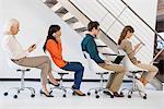 Business people sitting on chairs busy in different activities