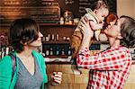 Two women, a same sex couple with their 6 month old baby in their coffee shop. business owners and parents.