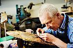 A clock maker busy in his workshop.