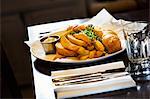 Village public house. A cooked dish on a dining table, fish and chips on a plate.